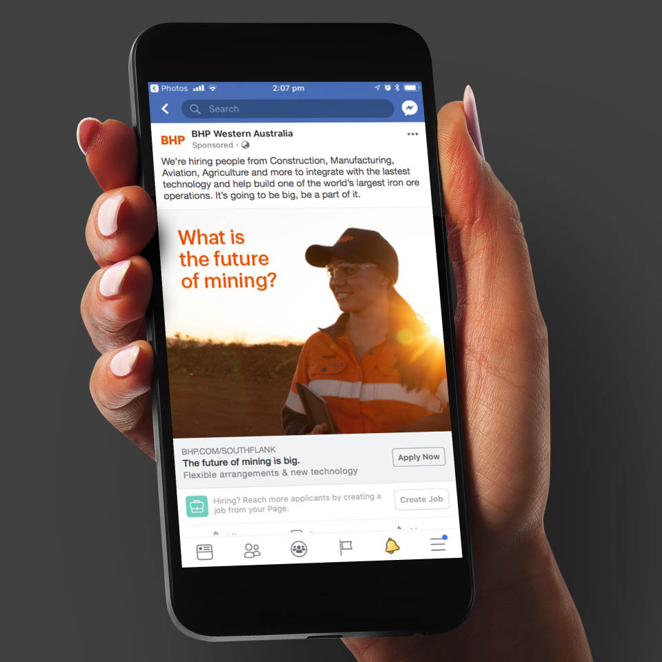 BHP South Flank Facebook advert shown on an iPhone held by a women's hand.