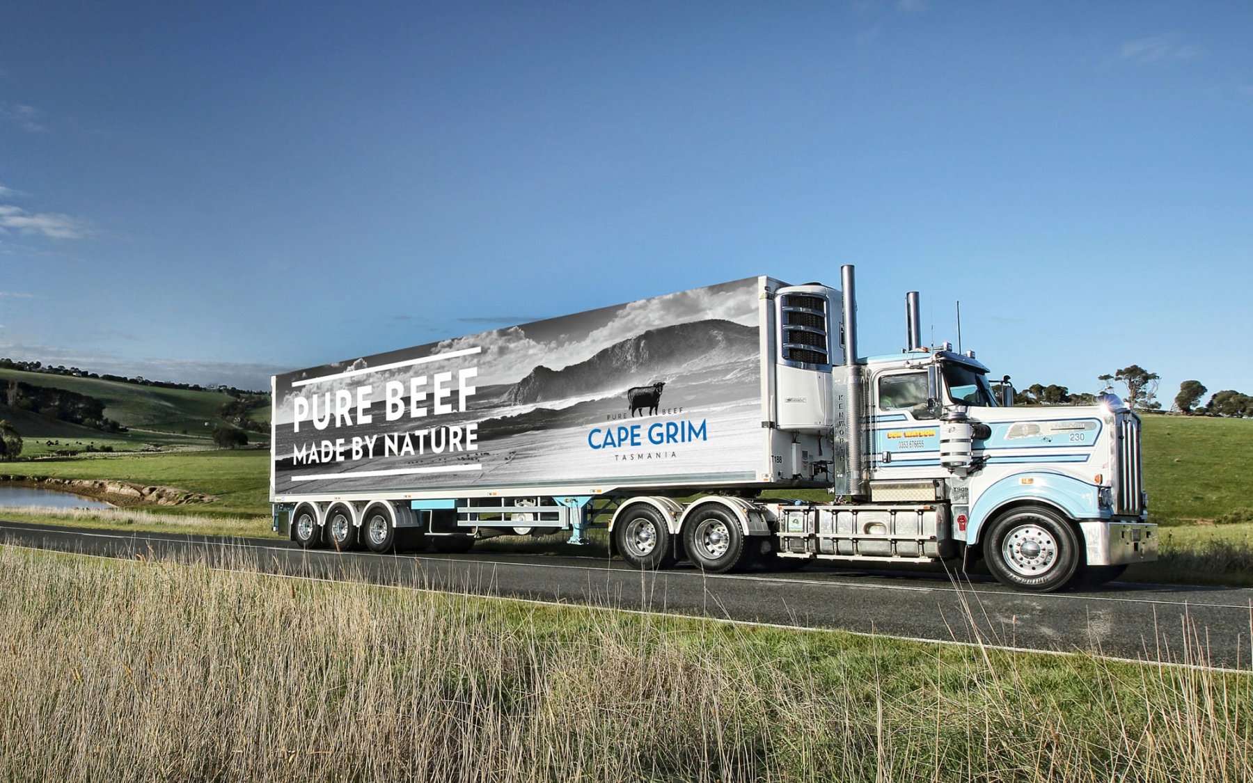 A truck with a billboard on its side driving down the road, showcasing an advertisement of Cape Grim.