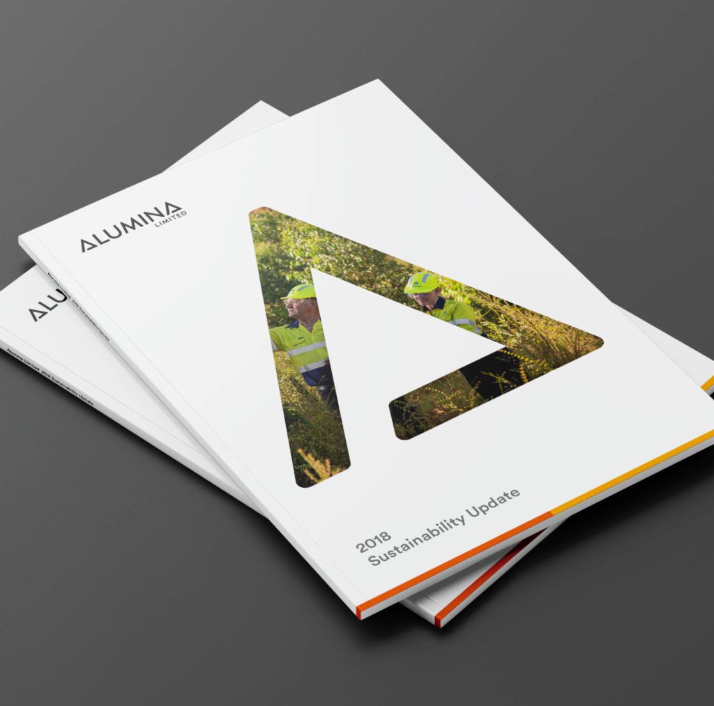 Stacked printed copies of the Alumina Sustainability report.